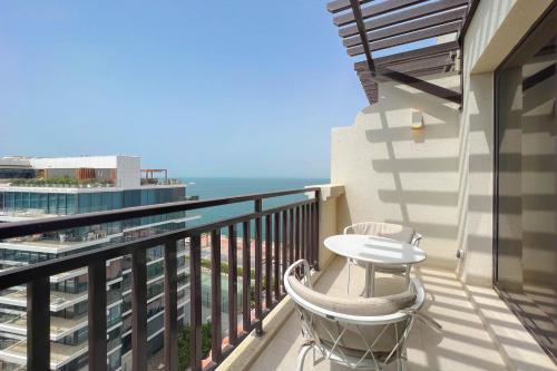 balcón con mesa y vistas al océano en Luxe Getaways Royal Amwaj Palm Jumeirah Resort Apartment Holiday Home en Dubái