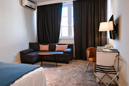 a hotel room with a couch and a window at Garni Hotel Le Petit Piaf in Belgrade