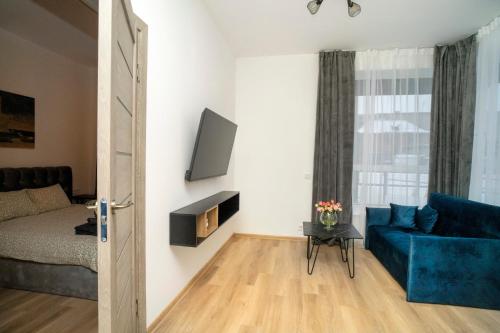 sala de estar con sofá azul y TV en Central Station Apartment No4, en Kaunas