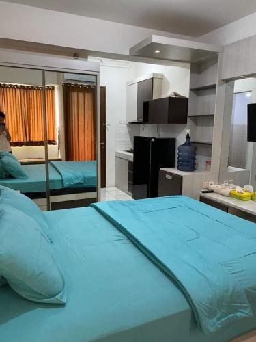een groot blauw bed in een kamer met een keuken bij SBroomOfficial Apartemen Riverview FREE WIFI AND NETFLIX in Tegalgede