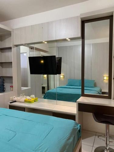 een slaapkamer met een bed en een grote spiegel bij SBroomOfficial Apartemen Riverview FREE WIFI AND NETFLIX in Tegalgede