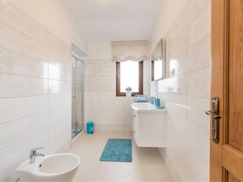 a white bathroom with a sink and a toilet at Villa Elize in Vabriga