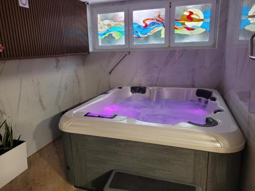 a bath tub with purple water in a bathroom at Hotel Olimp in Chojnice