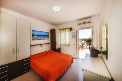 een slaapkamer met een bed met een oranje deken bij Hotel Incontro in Peschici