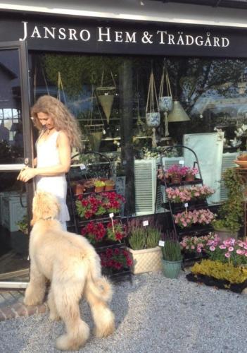 a woman and a dog in front of a flower shop at Arnhög Farm in Borrby