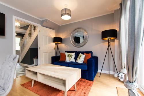 - un salon avec un canapé bleu et une table dans l'établissement Newly Renovated Modern House with FREE Parking, à Nottingham