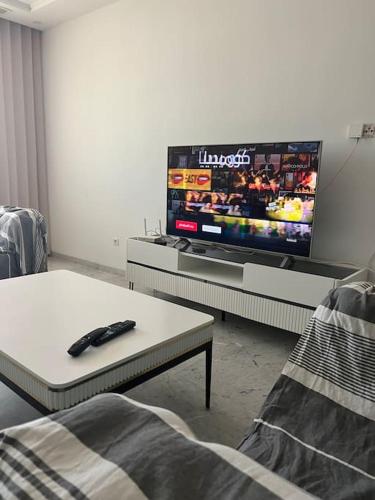 sala de estar con TV y mando a distancia en Luxury 2 bedrooms apartment jardin de carthage en Túnez
