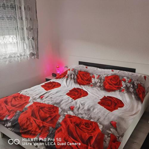 een slaapkamer met een bed met rode rozen erop bij Apartments Sara in Bosanska Krupa