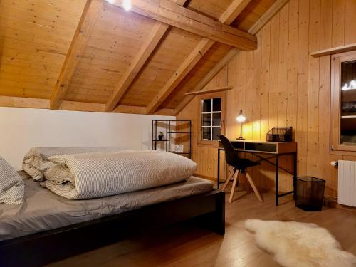 ライシーゲンにあるForest View Apartment in Leissigen by Interlaken with No Kitchenの部屋にベッドと机がある寝室