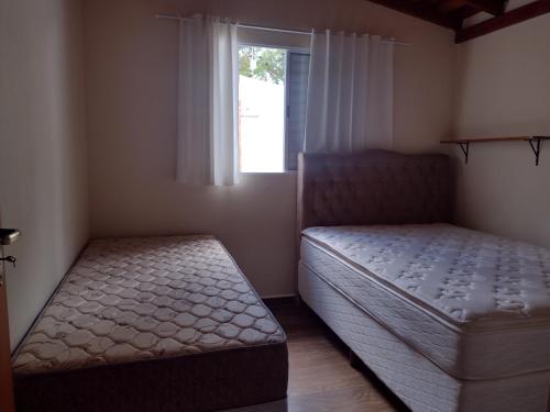 a bedroom with two beds and a window at Casa Mariano in Brotas