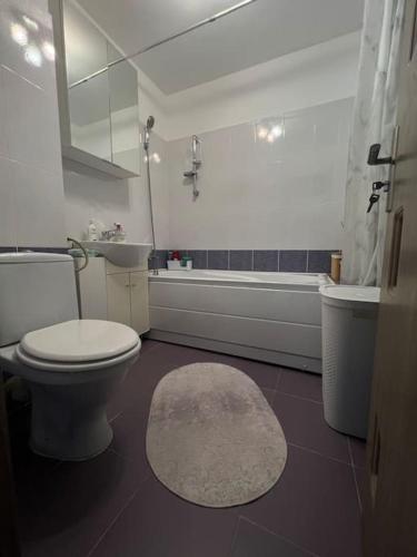 a bathroom with a toilet and a tub and a sink at Bucharest Apartment in Bucharest