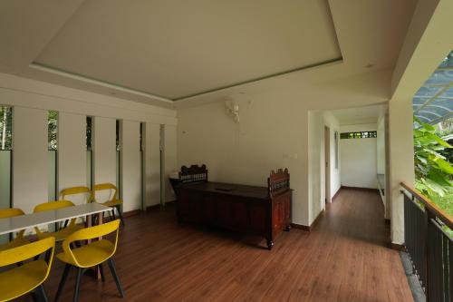 an empty room with chairs and a desk and tables at Royad Calicut Farm House - Premium Villa with Pool Inside a Farm in Kozhikode
