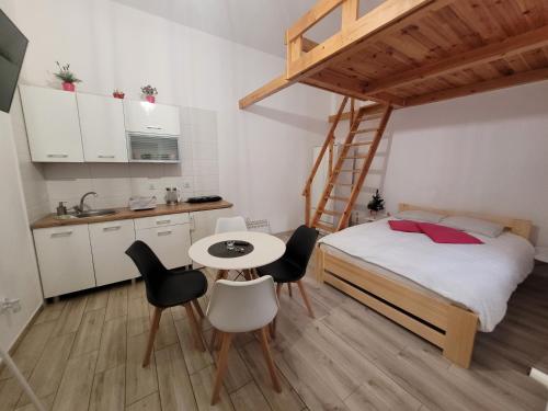 a small room with a bed and a table and chairs at Willa Nad Potokiem in Kudowa-Zdrój