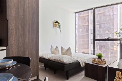 a bedroom with a bed and a window at A Chic 2BR Apt Right Next to Melbourne Central in Melbourne