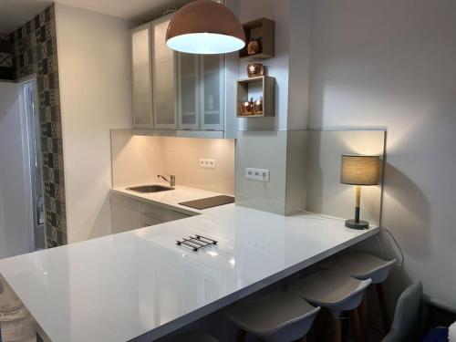 une cuisine avec un comptoir blanc et une lampe dans l'établissement Le fameux Montmartre, à Paris