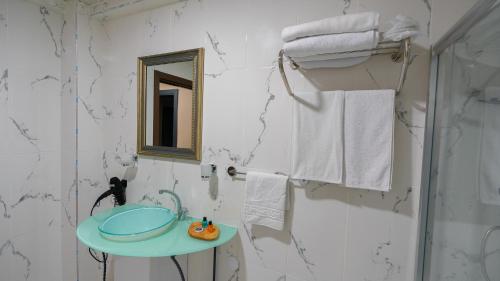 a bathroom with a sink and a mirror and towels at Gardan Hotel in Beylikduzu