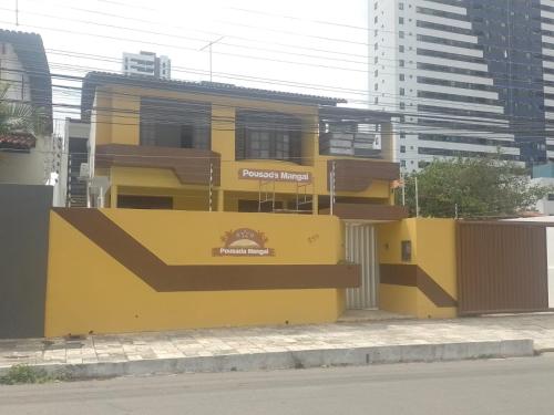 un edificio giallo sul lato di una strada di Pousada Mangai a João Pessoa