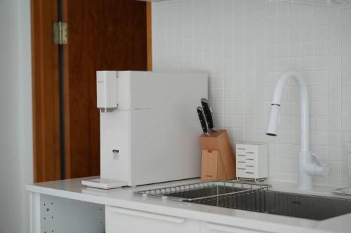 a kitchen counter with a white refrigerator and a sink at Stay Vibe Healing House in Seoul
