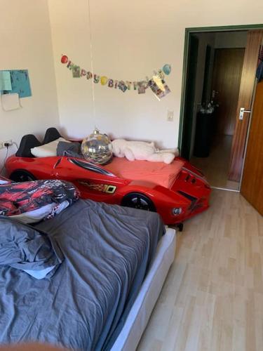 - une chambre avec un lit et une voiture rouge dans l'établissement Schöne Eigentumswohnung mit zwei Schlafzimmern ., à Biberach an der Riß