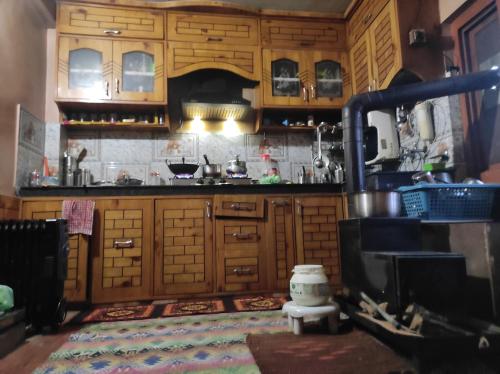 een keuken met houten kasten en een fornuis bij Himalayan Den in Shamshi