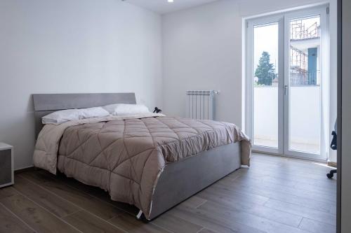 - une chambre avec un grand lit et une grande fenêtre dans l'établissement ANSIRO Apartment - Luxury Home, à Scisciano