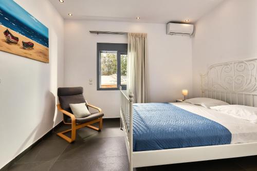 a bedroom with a bed and a chair at Villa Emilia - with private swimming pool in Agia Pelagia