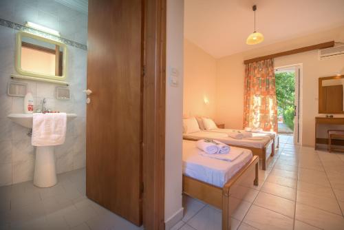 a bathroom with two beds and a sink in a room at Natasa Studios in Laganas