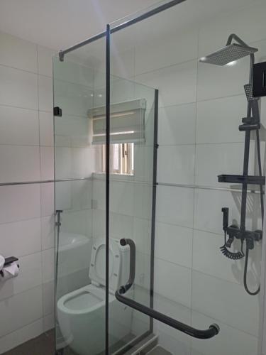 a glass shower stall with a toilet in a bathroom at Hotel Thirty Five in Lagos