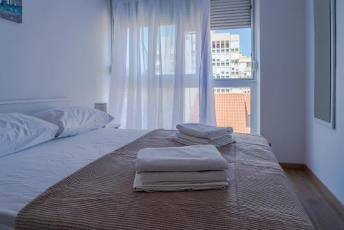 1 cama con toallas encima y ventana en Apartment Marijana en Split