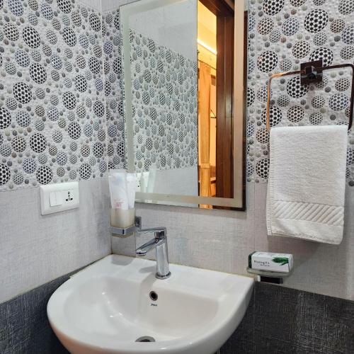 a bathroom with a white sink and a mirror at Riyavar Luxury Stay in Siddapur