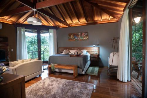 a bedroom with a bed and a couch at Pousada Terra Crua in Visconde De Maua