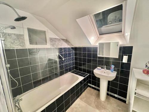 a bathroom with a bath tub and a sink at Greener Pastures - Normandy Self Catering Gites in La Chapelle-Engerbold