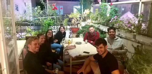 a group of people sitting around a table at Pretty Backpackers House in Da Lat