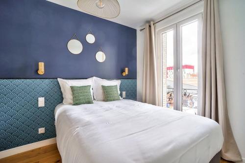 una camera da letto con un grande letto bianco con una parete blu di Splendid apartment for 2 people ad Aubervilliers