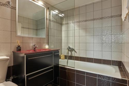 a bathroom with a tub and a sink and a toilet at City Center Modern Penthouse in Heraklio Town