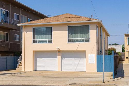 a house with two garage doors on a street at 28088 4B-Cozy & Quiet/Safe Bright 4brs Home in Daly City in Daly City