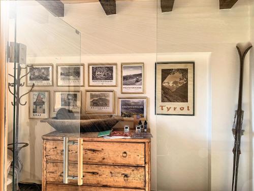 a glass room with a wooden dresser and pictures on the wall at Ein JUWEL "zum-Auerhahn" in Modriach