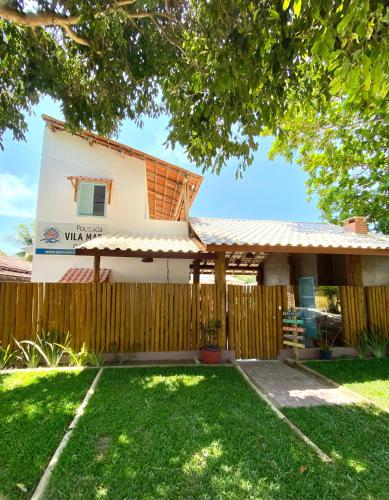 a house with a fence and a yard at Pousada Vila Mar in Itaúnas