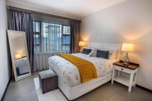 Un dormitorio con una cama grande y una ventana grande. en 29 eastpoint@pointwaterfront, en Durban