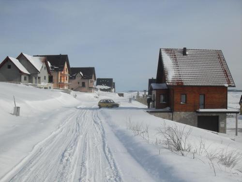 une voiture descendant dans une rue enneigée dans l'établissement Vila Ružica, à Kupres