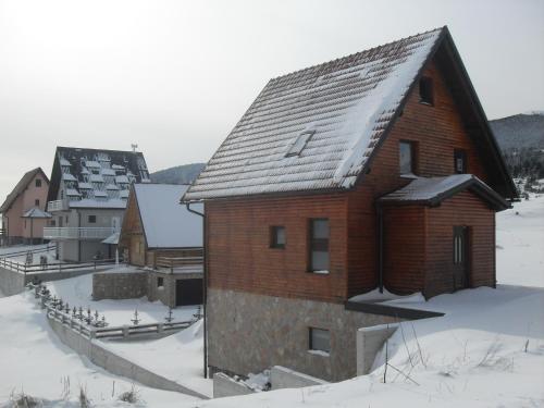 un grand bâtiment en briques avec de la neige sur le toit dans l'établissement Vila Ružica, à Kupres