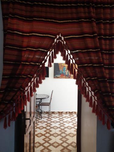 a room with a table and a red curtain at Blue heart in Chefchaouene
