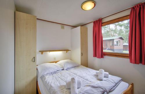 ein kleines Schlafzimmer mit einem Bett und einem Fenster in der Unterkunft Camping-und Ferienpark Havelberge in Groß Quassow