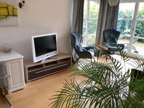 uma sala de estar com duas cadeiras e uma televisão em Ferienwohnung Schader em Prien am Chiemsee