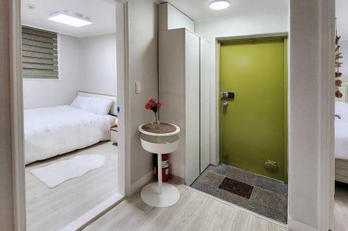 Habitación con cama y puerta verde en The Hari House, en Seúl