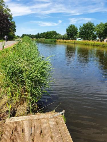 een rivier met gras aan de zijkant bij Camping de Oude Rijn in Ter Aar
