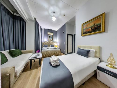 イスタンブールにあるHotel Mara İstanbulのベッド2台とソファが備わるホテルルームです。