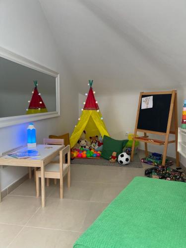 a childs play room with a table and a play tent at La Buhardilla in Moya