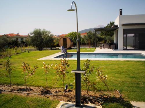 a street light in a yard next to a pool at Nostos Luxury Villas with Private Pool in Nafpaktos in Nafpaktos