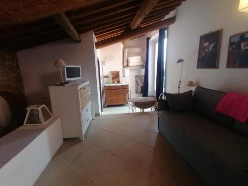 a living room with a couch and a television at Orbetello centro - Tramonto di Ponente casa indipendente in Orbetello